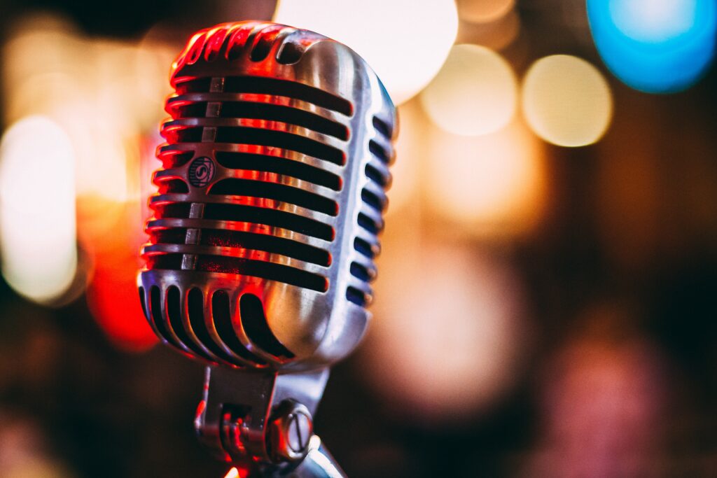 A close up of an old microphone with lights in the background